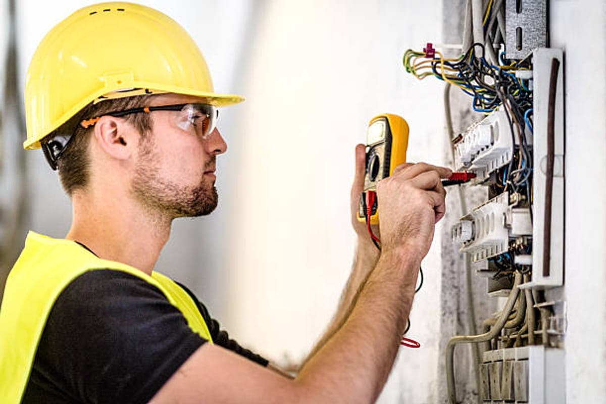 Elektriker kontrollerar en elcentral med en multimeter